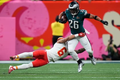 Saquon Barkley (26), corredor de los Eagles de Filadelfia, intenta eludir la tacleadade Bryan Cook (6), safety de los Chiefs de Kansas City