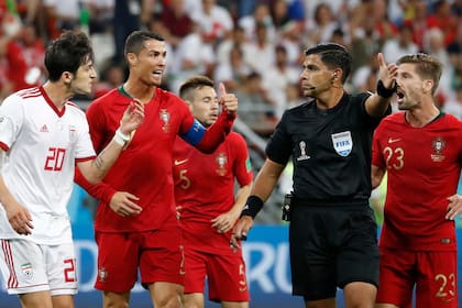 Sardar Azmoun de Irán, Cristiano Ronaldo de Portugaldiscuten con el referí Enrique Caceres