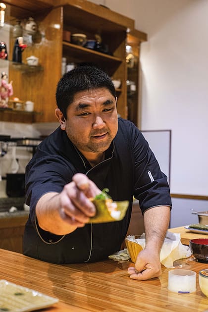Marcelo Arakaki ofrece un hand roll de trucha en su barra.