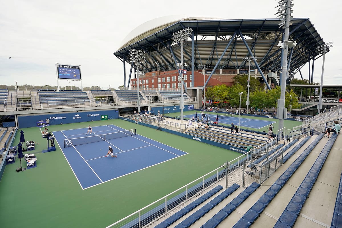 Schwartzman, en su partido en la cancha 5 frente a Cameron Norrie; al fondo, el imponente Arthur Ashe