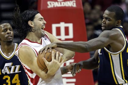 Scola defiende el balón ante la presión de Paul Millsap, de Utah; el argentino se convirtió en el hombre más importante de los Rockets