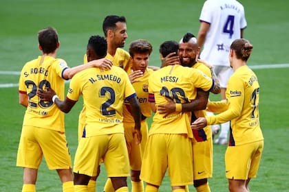 Se abrazan Messi y Vidal en el festejo grupal; el argentino hizo la asistencia al chileno para el gol de la victoria de Barcelona sobre Valladolid.
