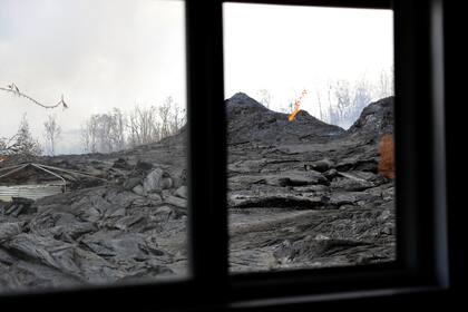 La lava del volcán vista desde la ventana de una casa, parte de su jardín ha desparecido