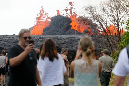 Las personas se acercan a ver el espectáculos de lava ardiente