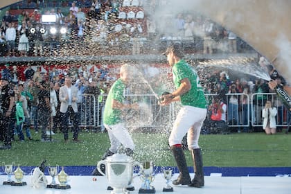 Se bañan de champaña Camilo Castagnola y Facundo Pieres, los delanteros de La Natividad, tras la conquista del Campeonato Argentino Abierto.