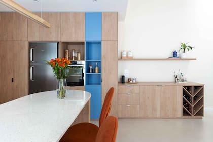 Se diseñó un mueble para alojar heladera y hornos, que continúa con una coffee-station y la bodega.