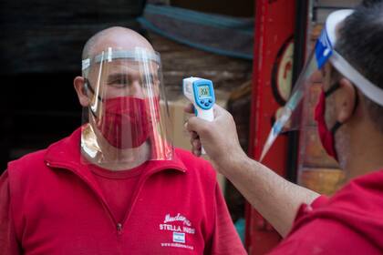 Los empleados se toman la temperatura antes de ingresar a la vivienda