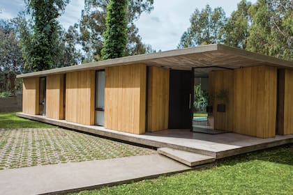 Se ingresa por el vértice, a través de una puerta negra que pivotea hacia una caja de vidrio que hace las veces de hall de recepción. El acceso vehicular y peatonal a través de una explanada en la que el pasto alterna con el piso, para integrar la naturaleza con la arquitectura.