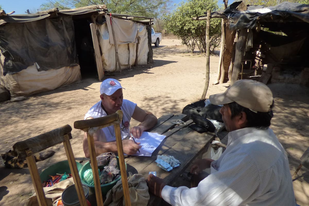 Se lo ve a José Boggiano, fundador junto a Marisa de Grupo Enashu, atendiendo a una persona en uno de sus operativos en Salta.