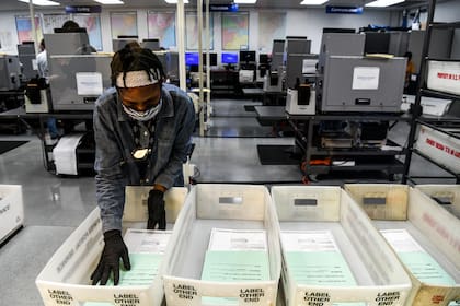 Un trabajador electoral durante el proceso de escaneo de boletas de votación por correo en el Departamento de Elecciones del Condado de Miami-Dade en Miami, Florida, en octubre de 2020