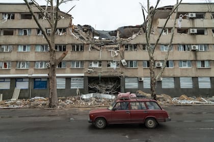 Se ve un automóvil pasar frente a los restos de un hotel alcanzado por un misil, en el centro de la ciudad de Mykolaiv, Ucrania, 2022-04-08
