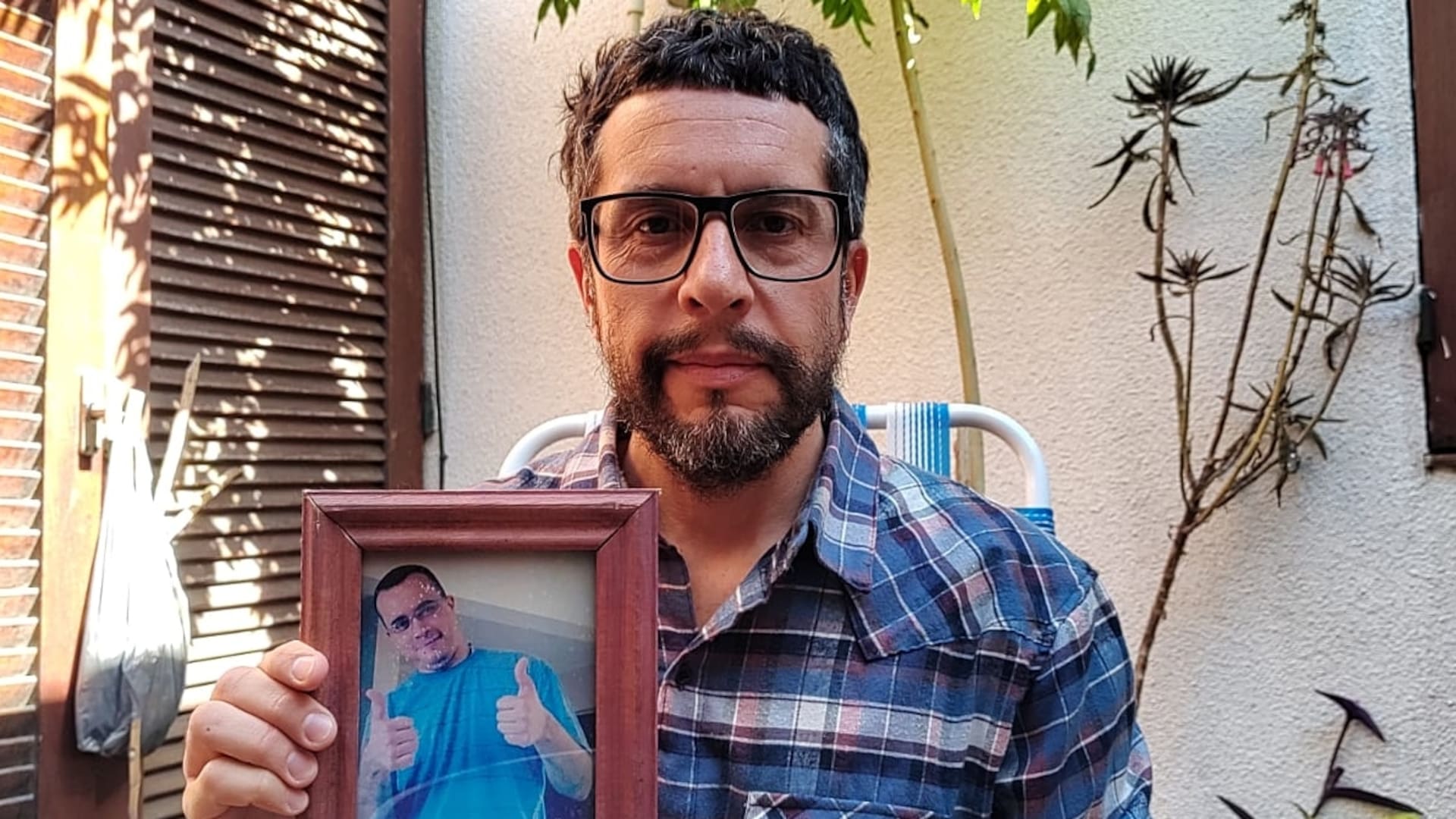 Sebastián Arce junto a una foto de su hermano, Juan Pablo, quien se suicidó a los 39 años