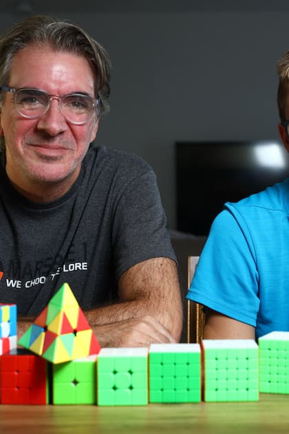 Sebastián Campanario y su hijo Nicolás juegan y promueven la competición con cubos Rubik.
