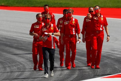 Sebastian Vettel, de pantalón oscuro, desanda la pista de Spielberg junto a miembros del equipo Ferrari; el piloto cerrará en 2020 el ciclo con la Scuderia y no tiene butaca para la próxima temporada