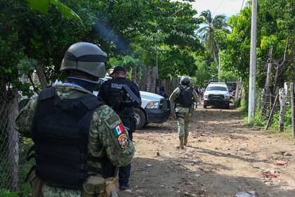 Las fuerzas de seguridad inspeccionan la zona donde al menos 11 policías murieron en una emboscada de grupos criminales en Coyuca de Benítez, estado de Guerrero, México, el 23 de octubre de 2023 (Archivo)