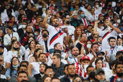 Seguidores alientan a las Chivas durante el clásico del fútbol mexicano ante el América, el sábado 12 de marzo de 2022 (AP Photo/Bruno Gonzalez)