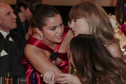 Selena Gomez compartiendo chismes con Taylor Swift durante la noche de la entrega de premios