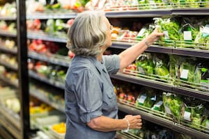 Senior woman picking out some vegetables in supermarket