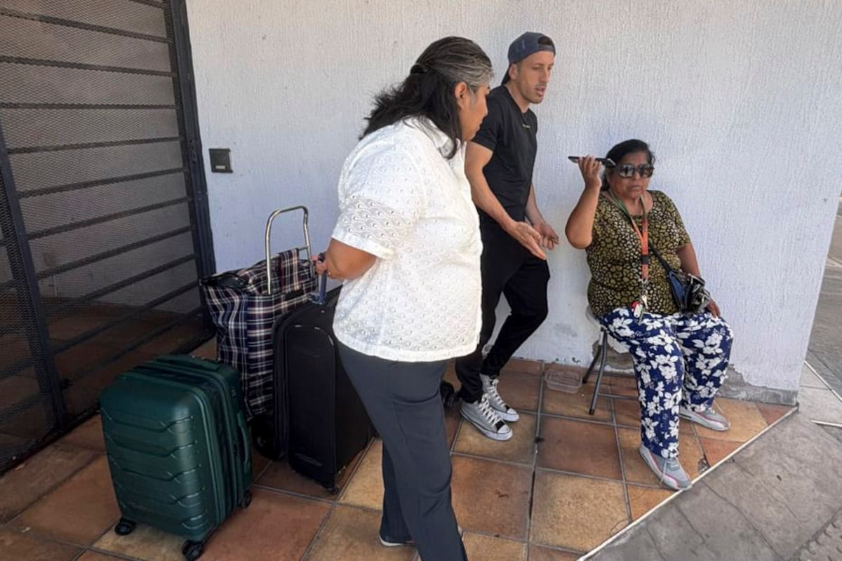 Sentada en una silla, Teresa Alfaro espera una autorización para ingresar a su departamento