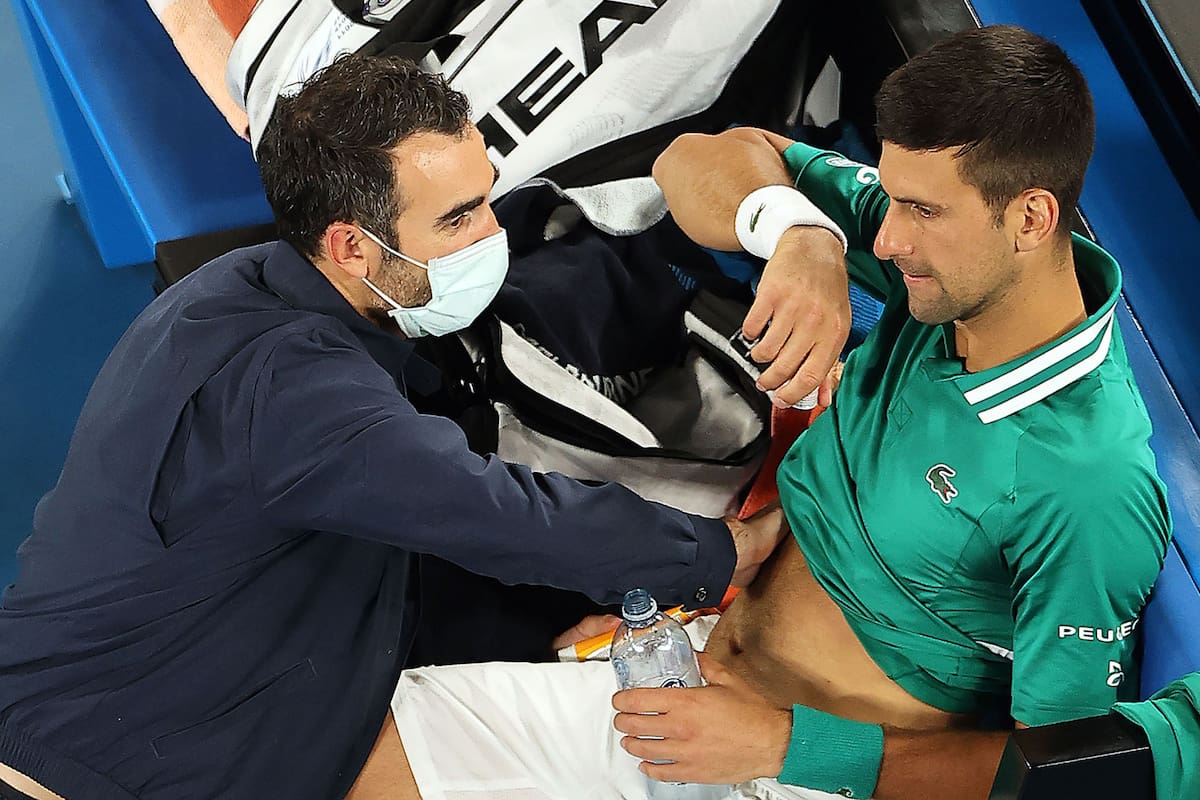 Serbias Novak Djokovic gets medical treatment while playing against Taylor Fritz of the US during their mens singles match on day five of the Australian Open tennis tournament in Melbourne