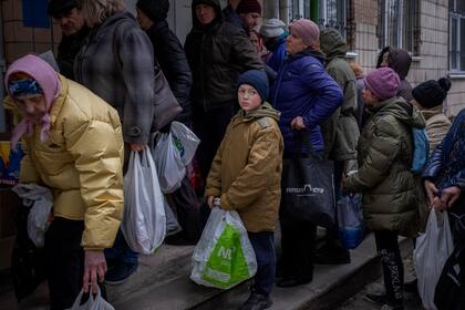 Sergei, de 11 años, espera su turno para recibir alimentos donados en Bucha, en las afueras de Kiev, el martes 19 de abril de 2022. (Foto AP/Emilio Morenatti, Archivo)