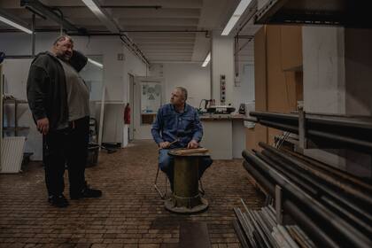 Serghei Liseniuc -a la derecha- quien llegó a Alemania desde Moldavia en 2015, habla con un instructor en un centro de formación regional en Dortmund, Alemania