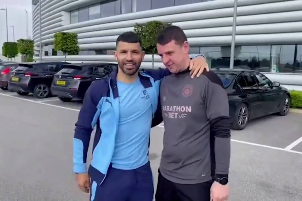 Sergio Agüero posa con el ganador del sorteo de su camioneta Range Rover, en el centro de entrenamientos de Manchester City.