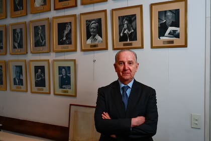 Sergio Baur posa junto a los retratos de los presidentes de la Academia Nacional de Bellas Artes