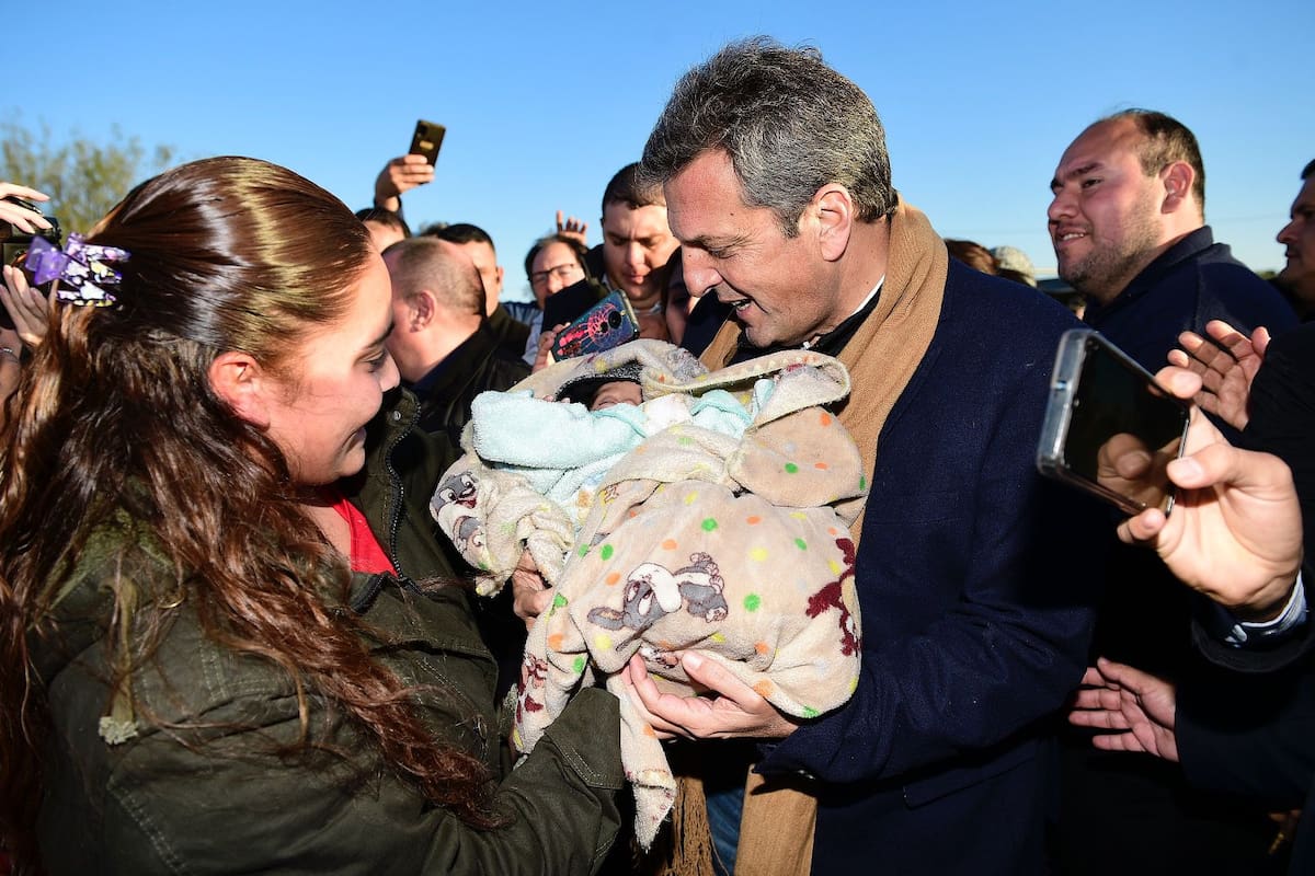 Sergio Massa en una postal bien de campaña: alza un bebé durante su participación en la Fiesta del Poncho, en Catamarca