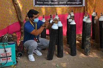 Shahnawaz Shaikh verifica la presión de un cilindro de oxígeno en un centro de distribución en un barrio pobre de Mumbai el 28 de abril de 2021