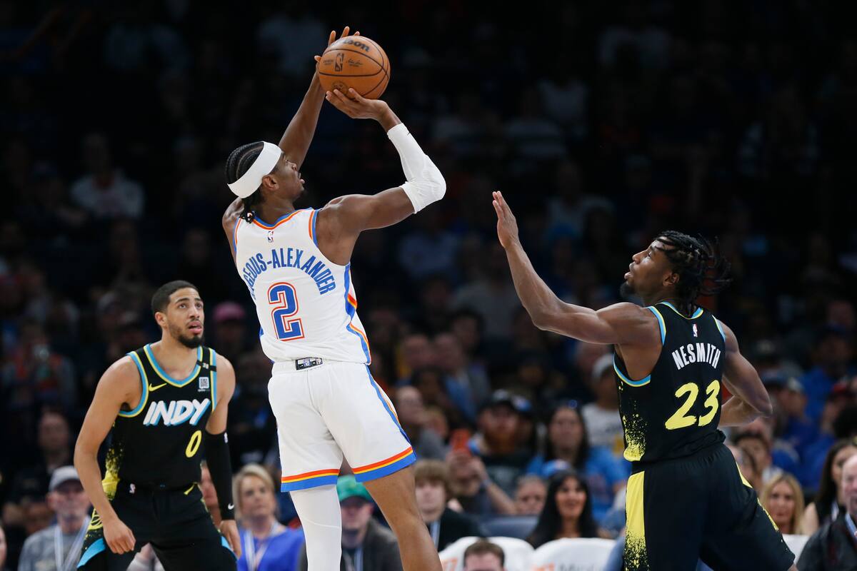 Shai Gilgeous-Alexander, de los Thunders, se eleva ante la mirada de Tyrese Haliburton y Aaron Nesmith, de los Pacers. (AP Foto/Nate Billings)