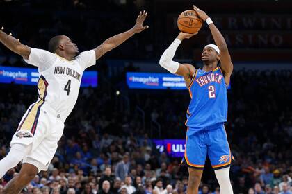 Shai Gilgeous-Alexander dispara por el Thunder de Oklahoma City frente a Javonte Green, de los Pelicans de Nueva Orleáns (AP Foto/Nate Billings)