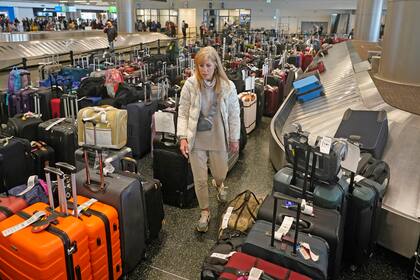 Shana Schifer, viajera de Chicago, revisa maletas no reclamadas en el área de Southwest Airlines en el Aeropuerto Internacional de Salt Lake City, el 29 de diciembre de 2022. (Foto AP/Rick Bowmer)