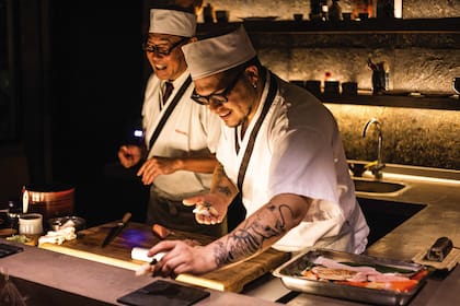 Sushimen sonrientes detrás de la barra