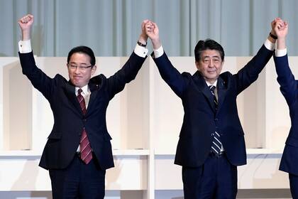 Shinzo Abe (der) y Fumio Kishida durante un acto partidista del 14 de septiembre del 2020 en Tokio, cuando Abe era primer ministro y Kishida ministro de relaciones exteriores. Ahora como primer ministro, Kishida tratará de cumplir los objetivos de Abe, su mentor, una tarea que no será fácil. (AP Photo/Eugene Hoshiko, Pool, File)