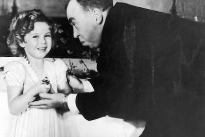 Shirley Temple recibiendo un Oscar especial de manos del guionista estadounidense Irwin S. Cobb en la ceremonia de los Premios de la Academia de 1935