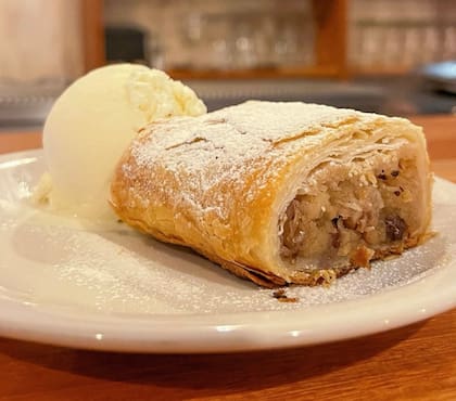 Si se deja un lugarcito, que sea para el dulce: el prefrido es este Apfelstrudel (strudel de manzana) con nueces y pasas acompañado con una bocha de helado de crema americana.