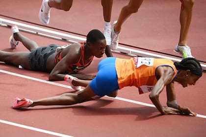 SIEMPRE SEGUIR. Sifan Hassan (con musculosa naranja) tropezó con otra atleta y cayó a metros del final pero se levantó, continuó corriendo, y no solo ganó esa competencia, sino que también se alzó con la medalla de oro en los 5000