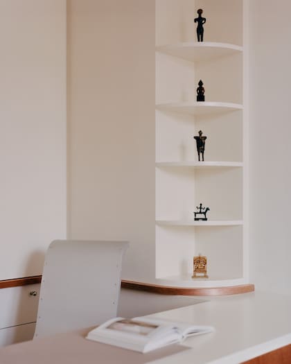 Silla ‘Romántica’, de Philippe Starck. El rincón se aprovechó con estantes empotrados donde se lucen pequeñas esculturas de Tailandia, Irán y Nepal.