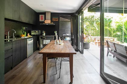 Sillas ‘Bertoia’ (Mercado Don Toto). Los muebles de cocina son de melamina texturada y se buscó que la mesada tuviera un aspecto similar: es de granito negro con terminación leather.