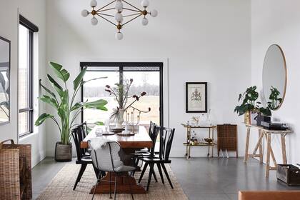 Sillas de madera ‘Windsor Fan Back’, sillones de malla metálica (Lostine para Urban Outfitters) y alfombra de yute ‘Lohals’ (Ikea). La araña, aporte de un amigo interiorista, completa el cuadro.