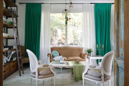 Sillas, mesa ratona y sillón (Arlequín Antigüedades). Lámparas de techo (María Pérez Deco). Cortinas en lino verde (De Levie). Manta tejida a mano (Mapuche Hecho a Mano).