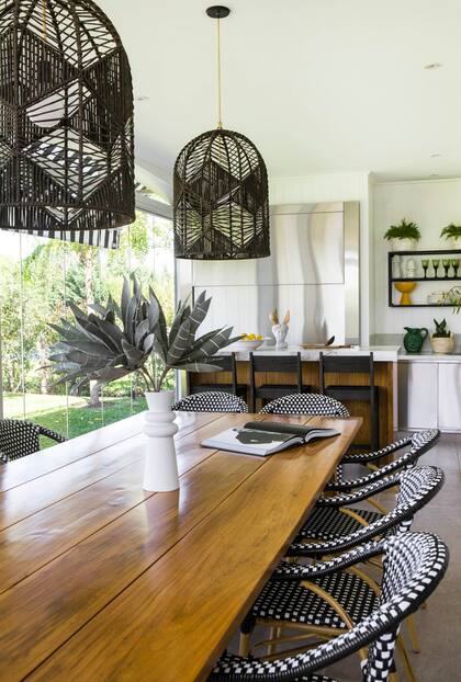 Sillas ‘París’ y lámparas de hilo natural
(Agustina Cerato). Paredews con listones de pintados de blanco. La barra combina tapa de Neolith con frente de madera. Parrilla con frente de acero inoxidable.