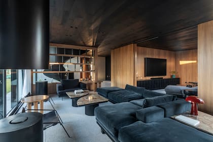 Sillón con base de madera y tapizado en terciopelo negro.