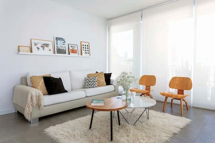 En el sector del living, sillón de tres cuerpos, sillas bajas, tapete y repisa angosta para cuadros, todo traído de la casa anterior. Además, mesas redondas (realizadas por KG Arq).