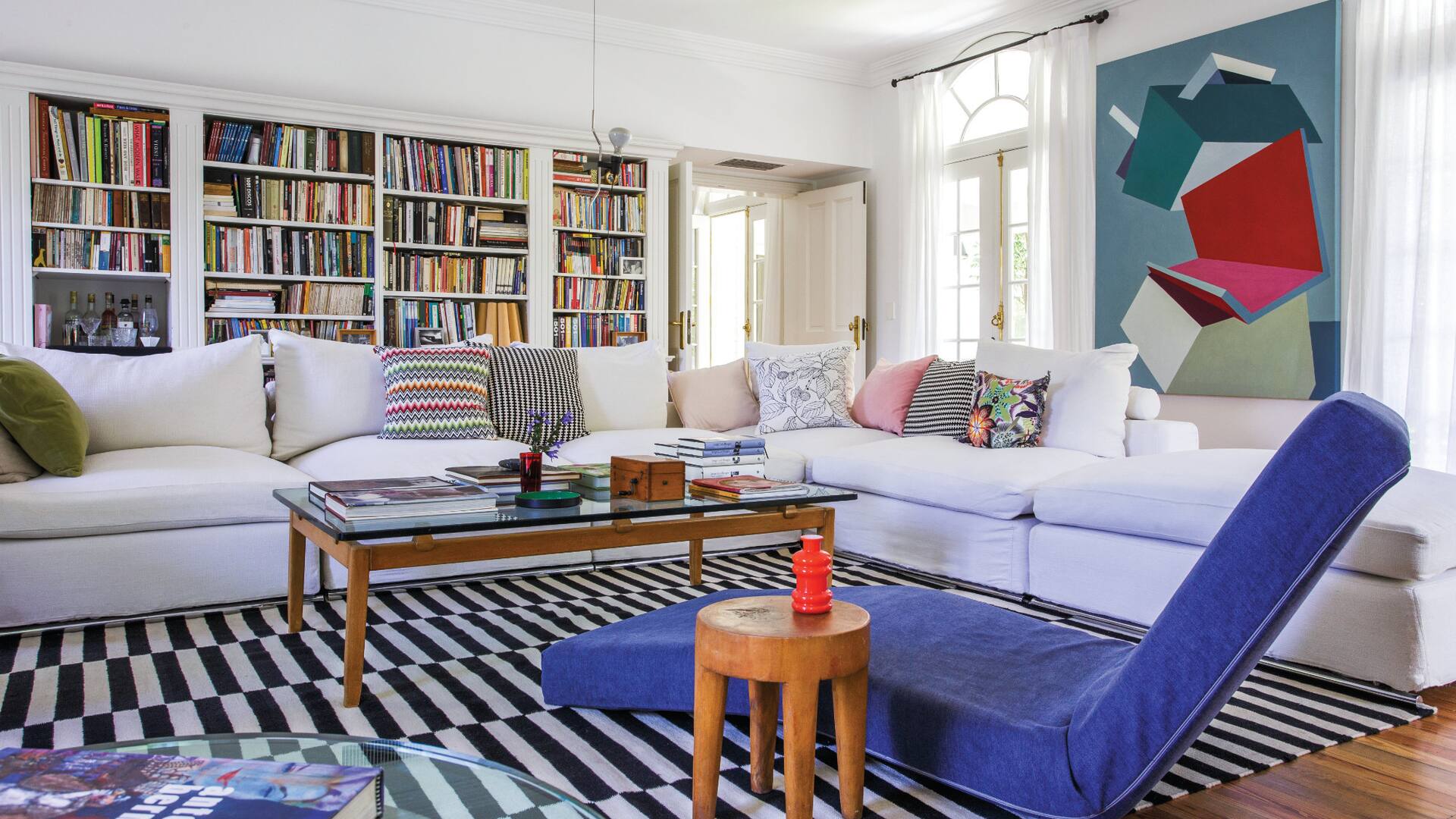 Sillón en L hecho a medida (MG Living) en base a un modelo de la firma italiana Flexform. Para la daybed articulable (Missoni) que le regalaron unos amigos, la dueña tiene varias fundas lisas y estampadas que va cambiando durante el año. Lámpara de suspensión ‘Paréntesis’, de Achille Castiglioni y Pio Manzù para Flos.