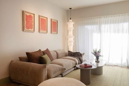 Sillón (Lobo Interiorismo) y almohadones (Philomena Home). Cuadros (Palmito Estudio). Mesas ratonas (Fusión a Medida) y lámpara de techo a piso (Dynamo Iluminación).