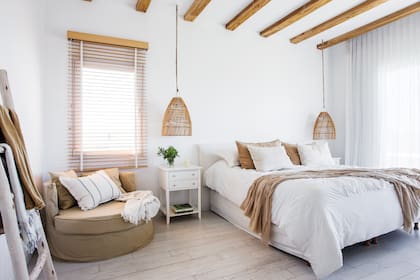 Sillón, mesa de luz, cortinas, textiles y ropa de cama (todo @cousy_home). Vela (Bohemia Velas). Persiana americana de madera (Wood Lovers). Lámparas (Compañía Nativa).