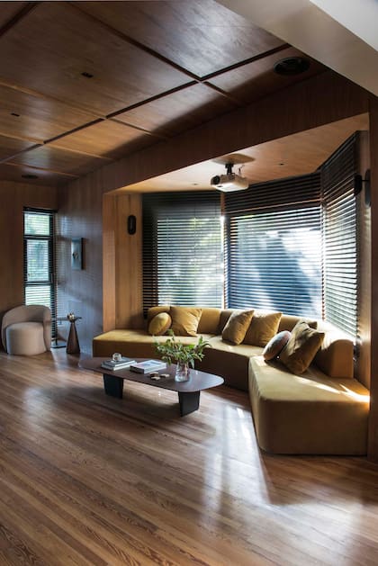 Sillón modular en terciopelo, diseño del Estudio para acompañar la bow window con persianas (Riel Americano). Mesa baja (Fontenla).