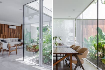 Sillón tapizado en bull (Landmark). Almohadones de pana (Gloria Atelier Deco). Mesa de madera maciza y sillas ‘Drew’ (Landmark). Espejo redondo biselado (Good Luck Casa). Cortinas ‘Multistore’ de bandas verticales (Rielamericano).